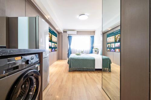 a small room with a bed and a washing machine at Xi'an Yongning Apartment Hotel in Xi'an