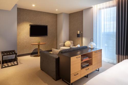 a hotel room with a couch and a tv at Hilton Woking in Woking