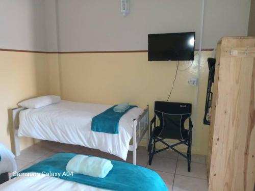 a room with two beds and a flat screen tv at OceanLife Guesthouse and Restaurant Lüderitz in Lüderitz