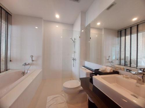 un bagno bianco con vasca, WC e lavandino di The Krabi Pelican Residence a Ban Ko Kwang