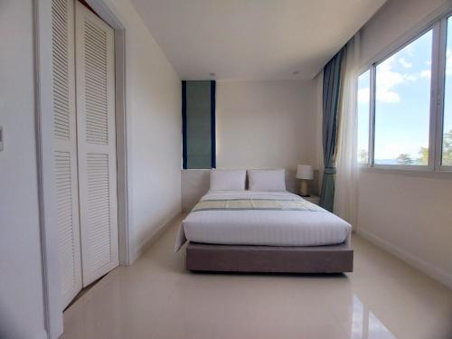 una camera da letto bianca con un letto e una finestra di The Krabi Pelican Residence a Ban Ko Kwang
