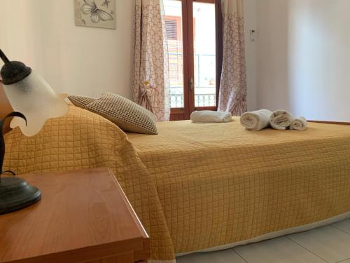 sypialnia z łóżkiem z ręcznikami i oknem w obiekcie Appartamento Casa Trento w mieście Castellammare del Golfo