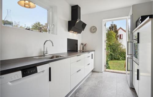 Ryomgårdにある2 Bedroom Cozy Home In Ryomgårdのシンクと窓のある白いキッチン