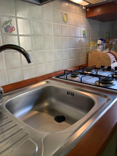 zlew ze stali nierdzewnej w kuchni z kuchenką w obiekcie Appartamento Casa Trento w mieście Castellammare del Golfo