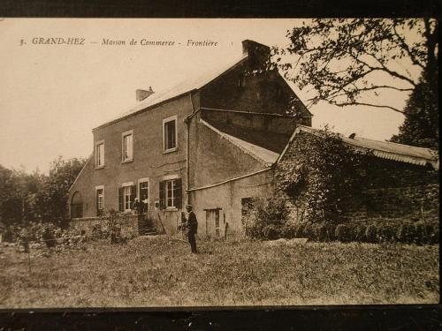 an old photo of a man standing in front of a house at L'aire des oiseaux in Muno