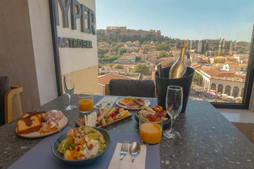 a table with plates of food and glasses of wine at Athens Tower in Athens