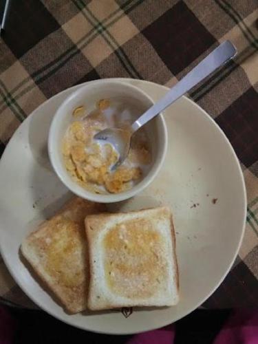 a plate with a bowl of food and two pieces of toast at Wanderlust Cottage Pangong Lake, Lukung, in Lukung