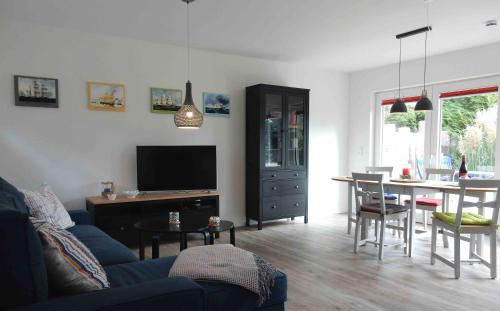 a living room with a blue couch and a table at Haus am Nordstrand 2 in Prerow
