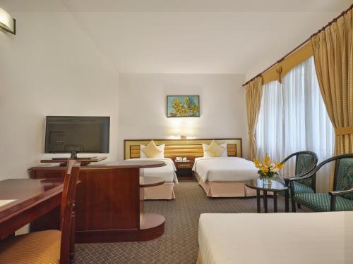 a hotel room with two beds and a flat screen tv at Bong Sen Hotel Saigon in Ho Chi Minh City