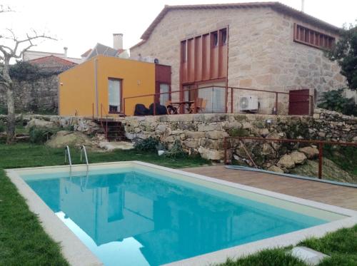 a house with a swimming pool in front of a house at Casa de Sao Cosmado in Mangualde