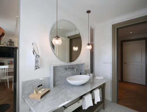 a bathroom with a sink and a mirror at LA MAISON hotel & spa in Saarlouis