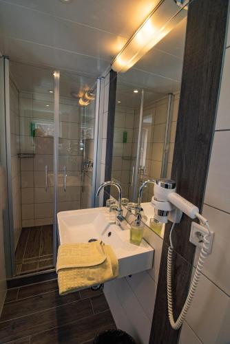 a bathroom with a sink and a mirror at Gasthof Braun in Schmallenberg