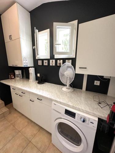 une cuisine avec une machine à laver sur un comptoir dans l'établissement Chez Céline Sous les Pins - Plages et Piscine, Océan et Lac, Vélos et Yoga!, à Vielle-Saint-Girons