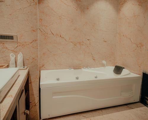 a bathroom with a white tub and a sink at Pushkara Resort and Spa, Pushkar in Pushkar