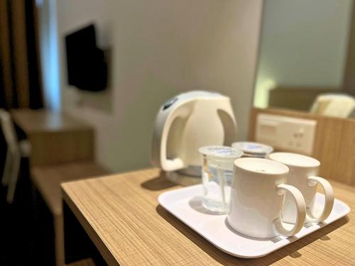 a table with two coffee mugs on a tray at Sky Hotel Chow Kit PWTC in Kuala Lumpur