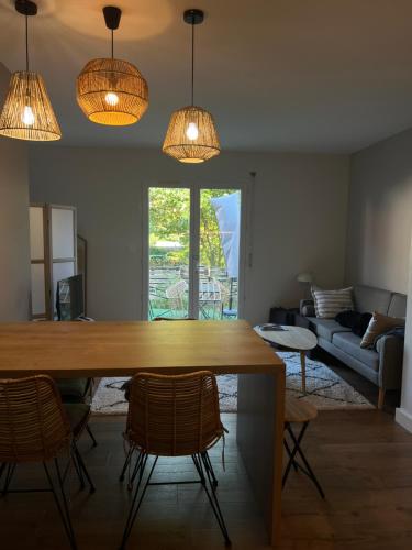 a living room with a table and chairs and lights at Appartement d'Exception à 20m de la Plage Votre Évasion Parfaite in Saint-Brevin-les-Pins
