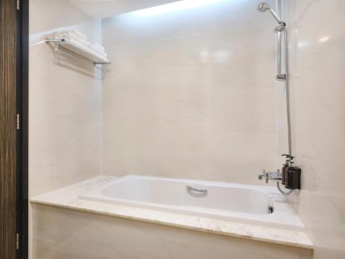 a white bath tub in a bathroom with a shower at Bong Sen Hotel Saigon in Ho Chi Minh City
