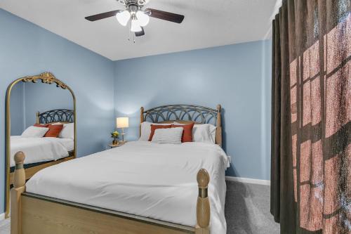 two beds in a bedroom with blue walls and a ceiling fan at Modern 6BR Haven with Playroom, Gym & Deck! home in Cartersville