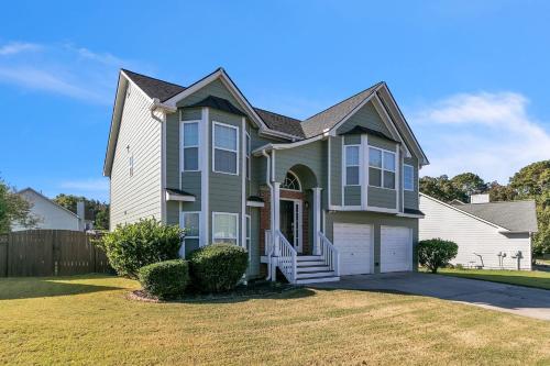 a house with a green and white house at Modern 6BR Haven with Playroom, Gym & Deck! home in Cartersville