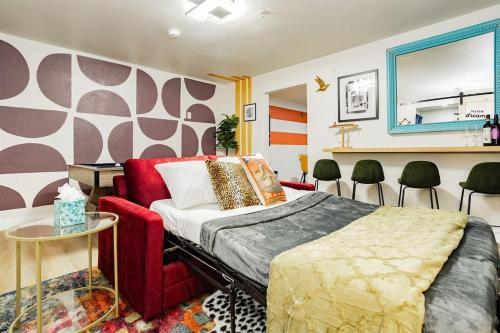 a bedroom with a bed and a red couch and chairs at Star Motel Unit 5- New Downtown Haven Boutique Las Vegas Oasis Home in Las Vegas