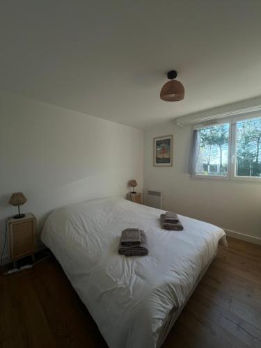 une chambre avec un lit blanc avec des serviettes dessus dans l'établissement Appartement d'Exception à 20m de la Plage Votre Évasion Parfaite, à Saint-Brévin-les-Pins