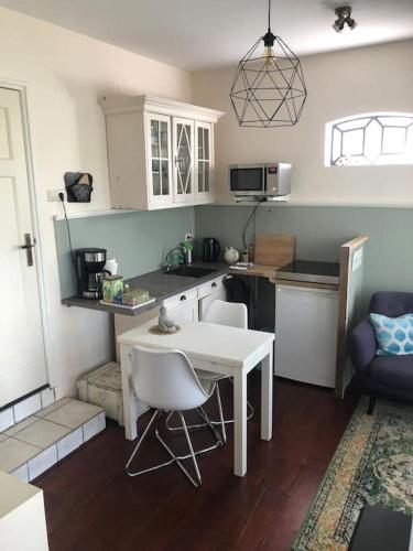 a kitchen with a white table and chairs in a room at Appartement voor twee personen in Twisk