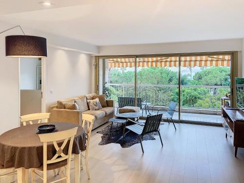 un salon avec un canapé et une table dans l'établissement Superbe appartement terrasse vue mer 347L GLEN, à Cannes