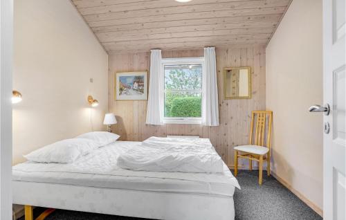 a bedroom with a white bed and a window at Holiday Home Pramvej Hjørring in Lønstrup