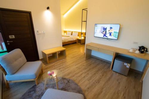 a living room with a couch and a tv on a wall at THE O-ZONE AIRPORT Riviera Lodge in Lat Krabang