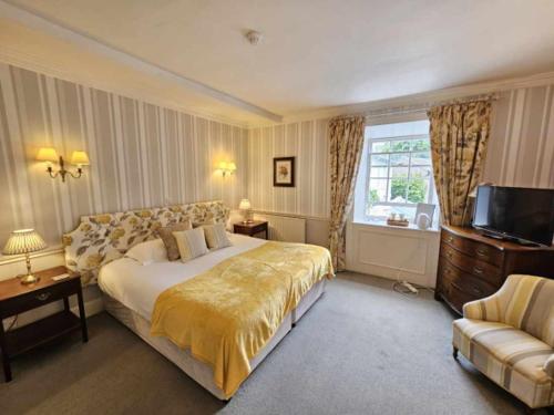 a bedroom with a large bed and a television at The Casterbridge in Dorchester
