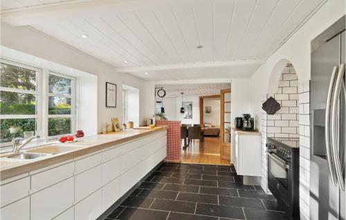 a kitchen with white cabinets and a black tile floor at 3 Bedroom Cozy Home In Løgstrup in Løgstrup