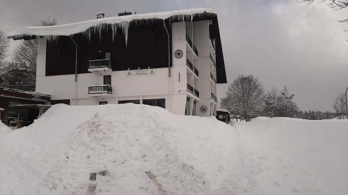 a pile of snow in front of a building at Apartmán Almberg - Mitterdorf - Mitterfirmiansrout in Philippsreut