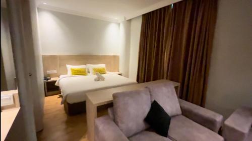 a hotel room with a bed and a chair at Sky Hotel Chow Kit PWTC in Kuala Lumpur