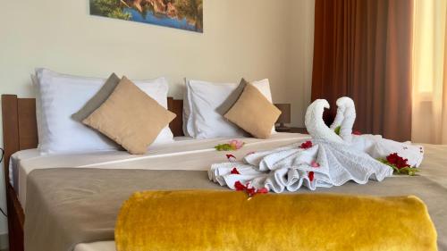 a hotel room with two beds with towels on them at The Palm Seychelles in Bel Ombre