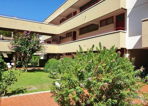 a building with a bush in front of it at ISA-Holiday Homes with common swimming-pool in Marina di Bibbona from 400 to 900 meters from the sea in Marina di Bibbona