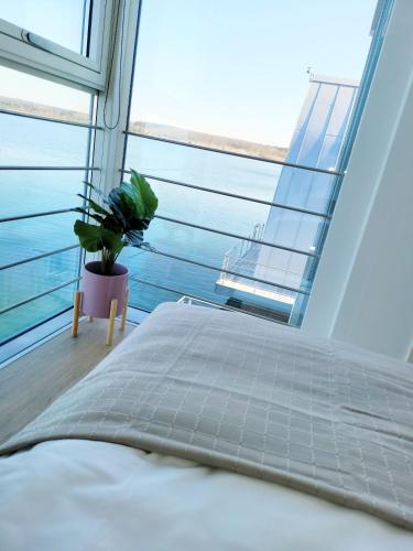 a bedroom with a bed and a large window at schwimmende Ferienwohnung Rooftop in Elsterheide