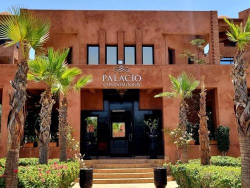 マラケシュにあるPalacio Hôtel Condominium Marrakechの前にヤシの木がある建物