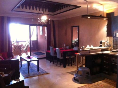 マラケシュにあるPalacio Hôtel Condominium Marrakechのテーブルと椅子のあるキッチンとダイニングルーム