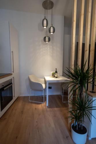 a room with a white desk and a table with a plant at DLG-STAYS Iserlohn in Iserlohn