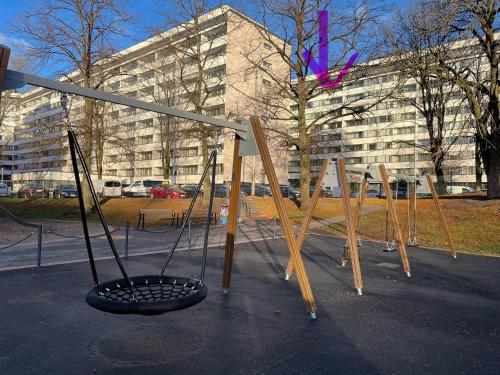 a group of wooden swings in front of a building at MP Kallio Apartment Helsinki in Helsinki