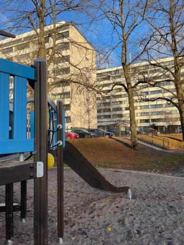 a playground in a park in front of a building at MP Kallio Apartment Helsinki in Helsinki