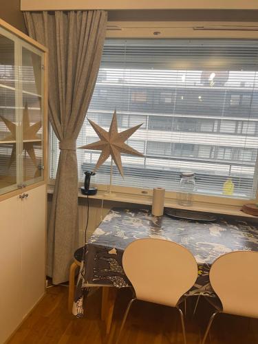 a table and chairs in a room with a large window at MP Kallio Apartment Helsinki in Helsinki