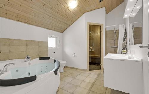 a bathroom with a tub and a toilet and a sink at Holiday Home Vibelunden Rødby V in Kramnitse