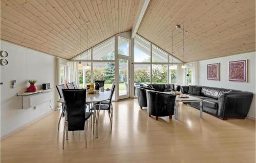 a living room with a couch and a table and chairs at Holiday Home Vibelunden Rødby V in Kramnitse