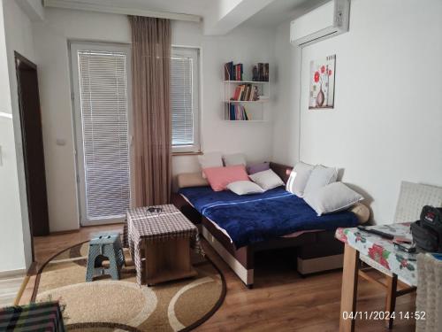 Kleines Zimmer mit einem Bett mit blauer Bettwäsche und Kissen in der Unterkunft BakaBaka in Pojate