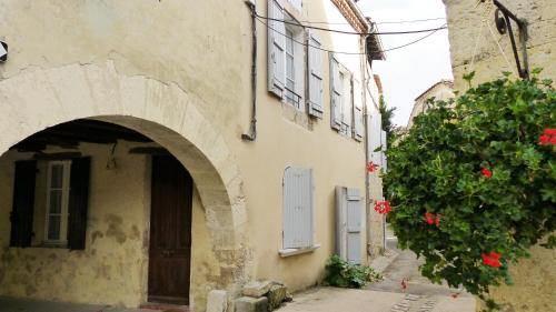 an entrance to a building with an arch and flowers at Les Hirondelles in Fourcès