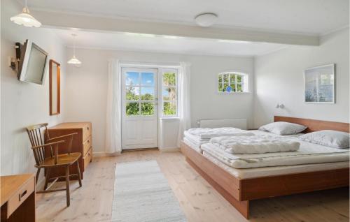 ToftebjergにあるAwesome Home In Samsø With Kitchenのベッドと机と椅子のある寝室