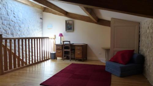 a living room with a chair and a desk at Les Hirondelles in Fourcès