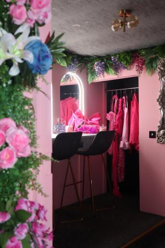 a pink dressing room with pink clothes and pink flowers at The Ultimate Hen Suite with Bar & Makeup Room in Manchester