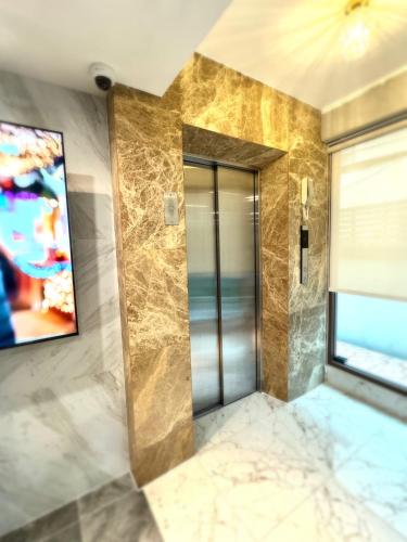 a bathroom with a glass door with a painting on the wall at Icon Dome Bangkok in Bangkok
